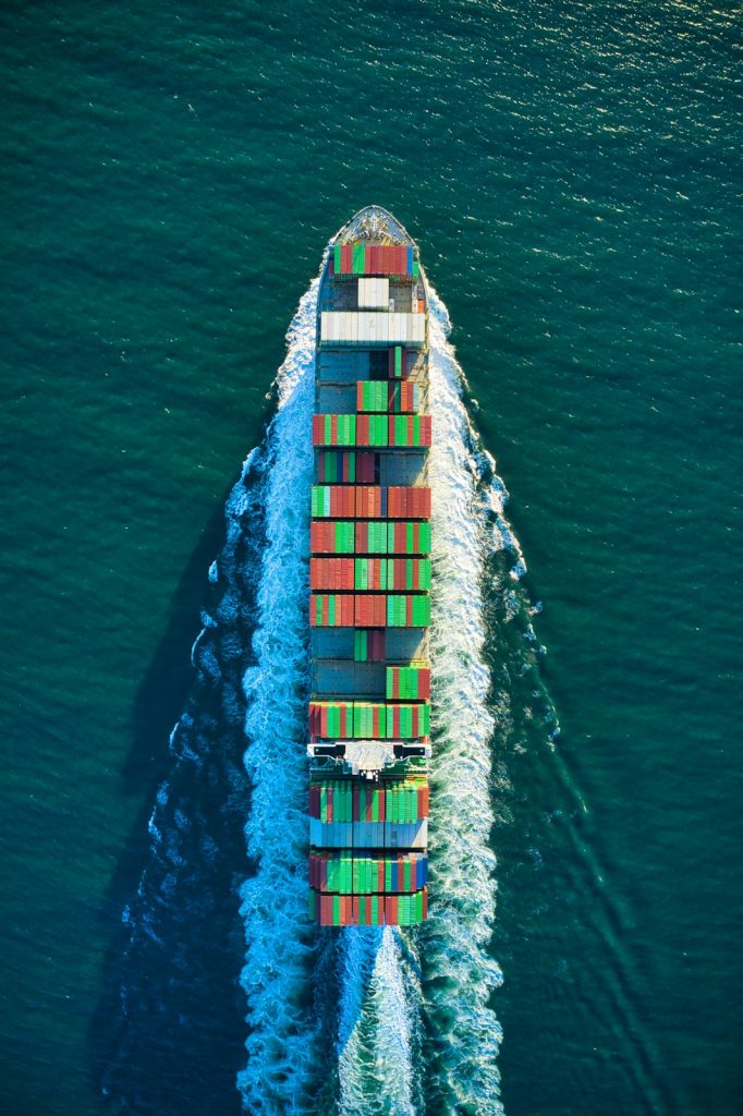 aerial view of blue and white boat on body of water during daytime